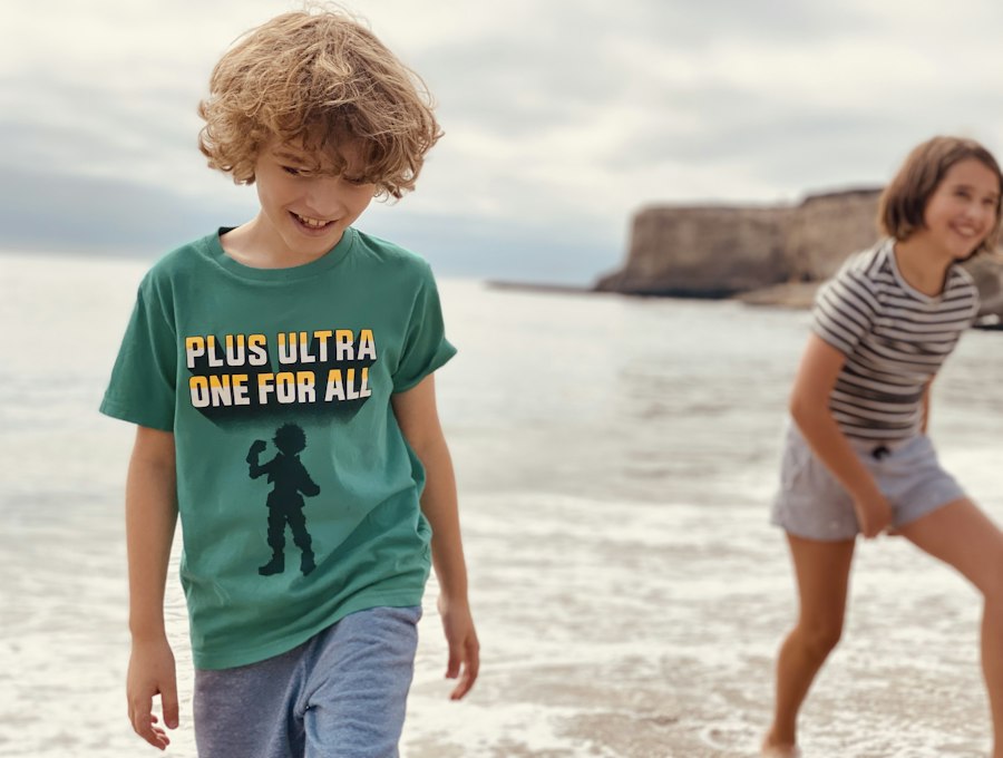 Two children playing on the beach in t-shirts and shorts