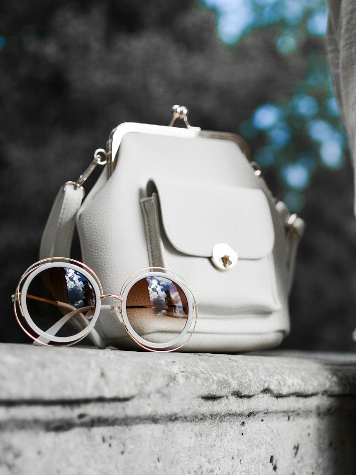White leather handbag and round sunglasses